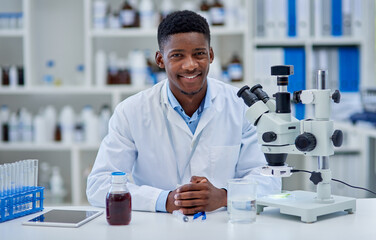Its been a long productive day. Portrait of a cheerful young male scientist standing at his desk inside of a laboratory during the day.