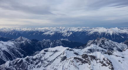 Obraz premium Aerial Panoramic View of Canadian Rocky Mountain Landscape. Cloudy Sunset Sky. Located near Vancouver, British Columbia, Canada. Nature Background Panorama