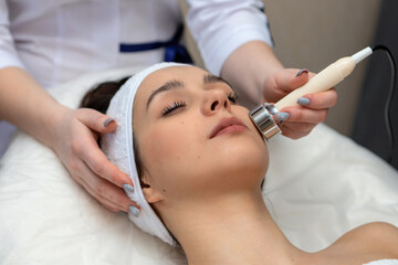 A girl's face in close-up during a facial treatment at a cosmetologist.The cosmetologist does biomechanical stimulation of the face to the client.The concept of professional cosmetology.