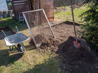 Erde wird im Garten gesiebt