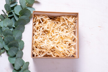 Brown cardboard carton box with filler decorated with Eucalyptus green branch