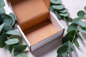 White cardboard carton box decorated with Eucalyptus green branch