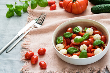 Caprese salad with tomatoes, mozzarella, basil and olive oil. Healthy mediterranean food concept. Close-up photography.