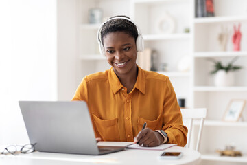 Cheerful black woman student having online class at home