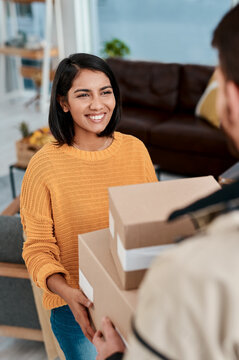 If theyre smiling, they did a good job. Shot of a young woman receiving a package from a delivery man at home.