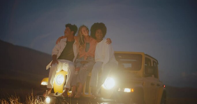 Three best friends relaxing at dusk on epic summer road trip, adventure and nomadic lifestyle
