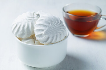 Vanilla Marshmallow dessert zephyr with cup of tea on the table. Airy Meringue dessert in a white bowl on the white background. traditional Russian sweet dessert. copy space