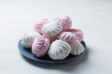 pink and white marshmallows. vanilla Marshmallow dessert zephyr on the table. Meringue dessert with green mint in a grew plate on the white background. traditional Russian sweet dessert. copy space