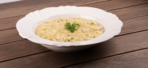 risotto with green onions on wooden table