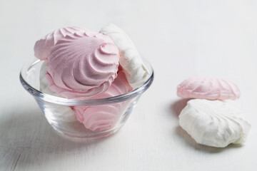 Obraz na płótnie Canvas Pink and white Marshmallow dessert zephyr on the table. Meringue dessert in a glass bowl on the white background. traditional Russian sweet dessert. copy space.