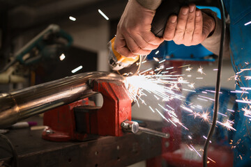 Technician worker cutting metal with many sharp sparks. Using equipments to cat iron