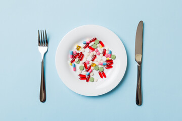 Many different weight loss pills and supplements as food on round plate. Pills served as a healthy meal. Drugs, pharmacy, medicine or medical healthycare concept