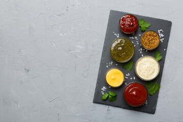 Many different sauces and herbs on table, flat lay top view. sauces on plate, healthy concept