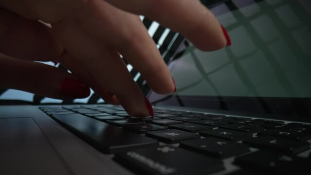 Woman hand working on laptop computer. Close up female fingers typing buttons on notebook. Dolly shot of female fingers pushing keys on computer keyboard and chatting in social network. Slow motion.