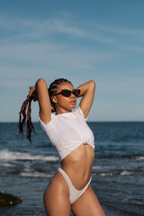 Young african american woman with braids hairstyle enjoying the beach on a sunny day
