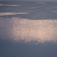 Sun glare on the surface of the river in spring. Morning landscape.