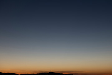 The sky before dawn was clear with an orange horizon and a blue atmosphere. orange dawn sky smooth orange gradient background of the start of the day Morning paradise with copy space. Sunset. Sunrise 