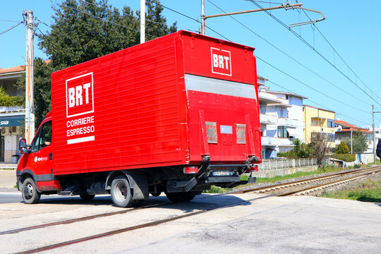Italy &ndash; March 22, 2022: BRT Bartolini Express Courier truck in movment on railroad intersection. BRT Bartolini is an Italian express transportation and delivery