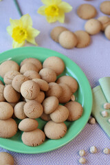 close up of fresh homemade hazelnuts kookies in a green plate