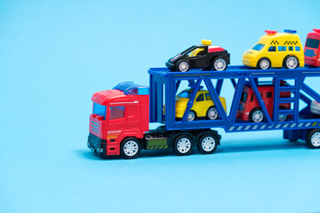 Toy car transporter with cars on a blue background, for a toy store.
