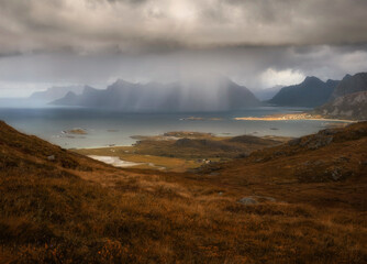 Heavy rain and sun over mountains and sea at Lofoten Islands in autumn Norway time