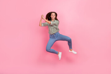 Photo of dreamy lucky lady dressed green shirt jumping high rising arms together isolated pink color background