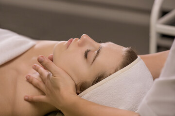 Obraz na płótnie Canvas Face massage. Close-up of young woman getting spa massage treatment at beauty spa salon.