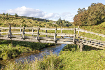 Fototapeta na wymiar A wooden footbridge over Conglass Water at Blairnamarrow near Tomintoul, Moray, Scotland UK.