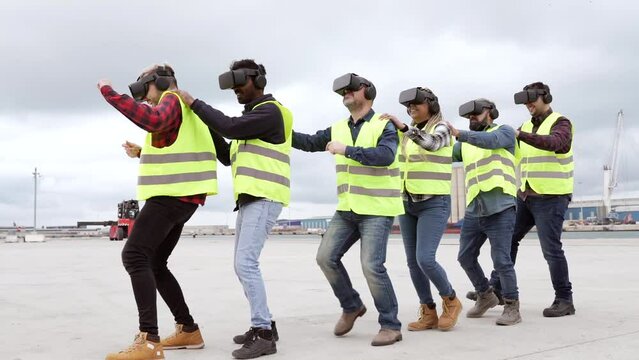 group of container port cargo workers using vr graphics dancing together in virtual reality. Multi-racial team of industrial workers - Metaverse and concept of logistics -