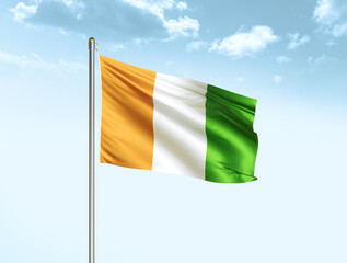 Cote d'ivoire national flag waving in blue sky with clouds. Ivory Coast flag. 3D illustration