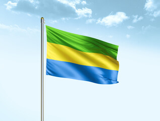 Gabon national flag waving in blue sky with clouds. Gabon flag. 3D illustration