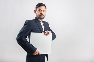 well dressed suit man holding a white empty board looking towards camera