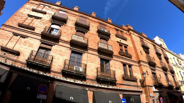 Sevilla, Spain, September 12, 2021: PAN SLOW MOTION SHOT - Colorful buildings of the Calle Arfe Street.