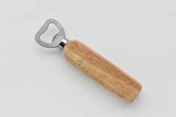 A top view image of a wooden handled bottle opener on a light grey background. 