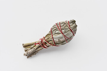 A top view image of a single sage smudge stick on a white background. 