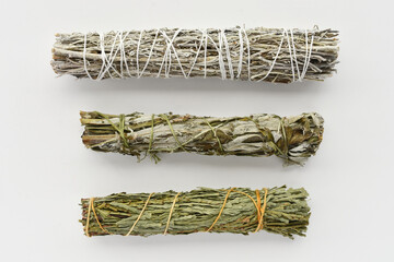 A top view image of three different types of healing smudge sticks on a white background. 