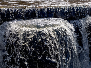 Water runoff illuminated by the winter sun on the water threshold on the storm canal of the Kalety...