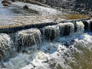 Water runoff illuminated by the winter sun on the water threshold on the storm canal of the Kalety...