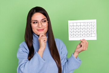 Photo of pretty young brunette lady look paper wear blue pullover eyewear isolated on green color background