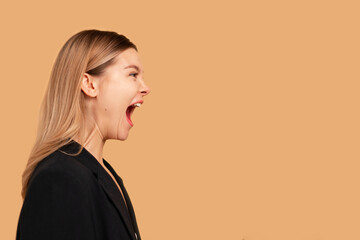 Young business woman screaming loud side view isolated on color background. Caucasian female...