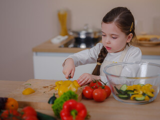 Young Girl Vlogger Making Social Media Video About Cooking At Home, looking on smartphone on tripod. episode about healthy eating. concept of attraction children to healthy diet of early age