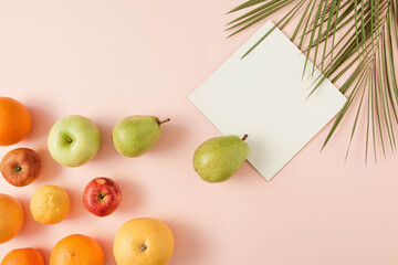 Summer tropical layout made of fresh fruits and green palm leaves on a pastel pink background. Minimal flat lay. Copy space.Food organic.