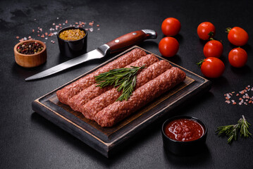 Fresh raw mince for grilled kebab with spices and herbs on a dark concrete background
