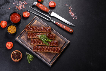 Grilled kebab with spices and herbs on a dark concrete background