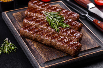 Grilled kebab with spices and herbs on a dark concrete background