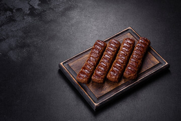 Grilled kebab with spices and herbs on a dark concrete background