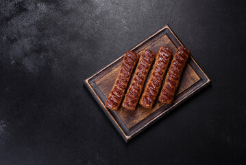 Grilled kebab with spices and herbs on a dark concrete background