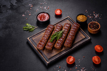 Grilled kebab with spices and herbs on a dark concrete background