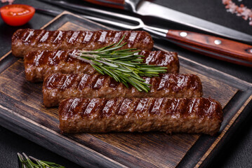 Grilled kebab with spices and herbs on a dark concrete background