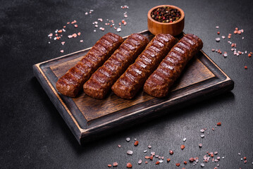 Grilled kebab with spices and herbs on a dark concrete background